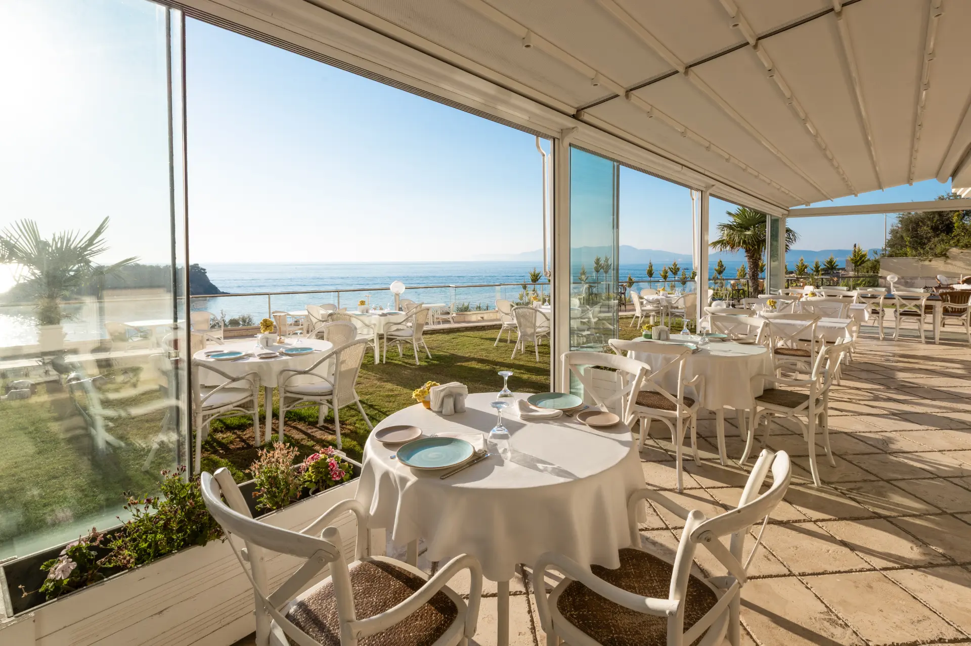 Glass-walled restaurant terrace overlooking the Aegean